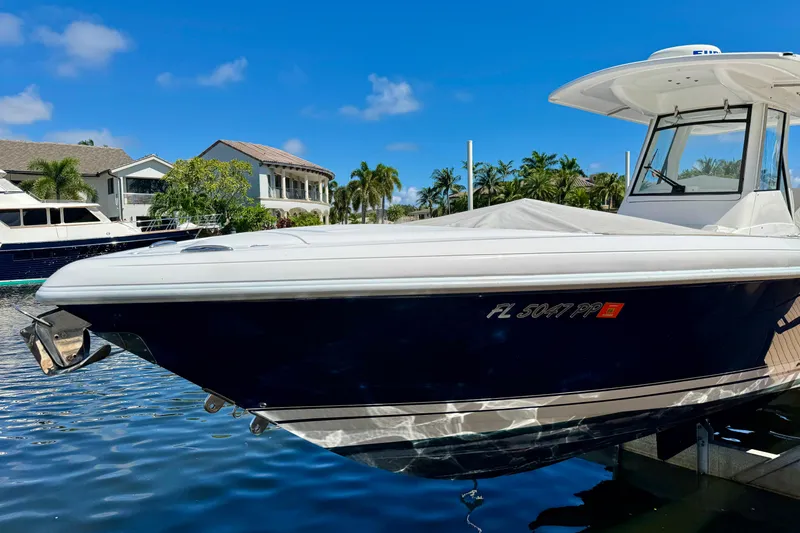 Slide: The Image of 2014 Intrepid 327 Center Console boat docked in sunny waterfront setting. - 5