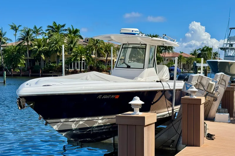 Slide: The Image of 2014 Intrepid 327 Center Console boat docked in sunny marina setting. - 6
