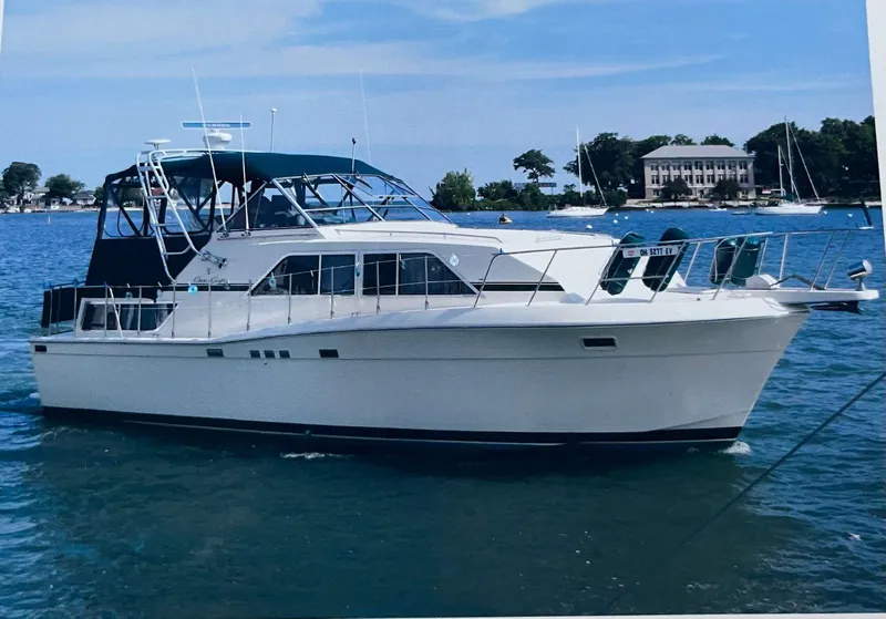 The Image of 1987 Chris-Craft 381 Catalina yacht on calm water, blue canopy, scenic background. - 0