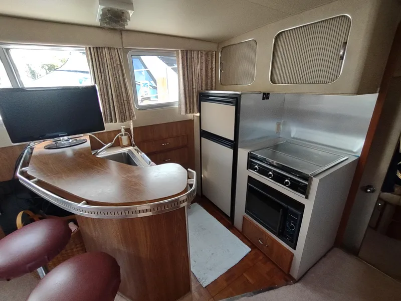 Slide: The Image of 1987 Chris-Craft 381 Catalina interior with kitchen, bar, and seating area. - 15