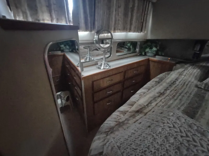Slide: The Image of 1987 Chris-Craft 381 Catalina cabin interior with wooden drawers and a bed. - 28