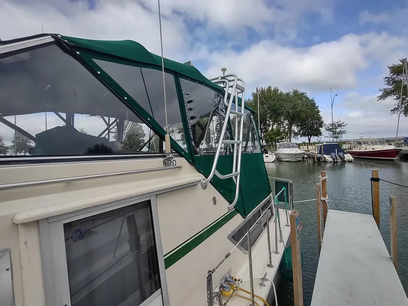 Slide: The Image of 1987 Chris-Craft 381 Catalina docked, featuring green canopy and marina backdrop. - 3