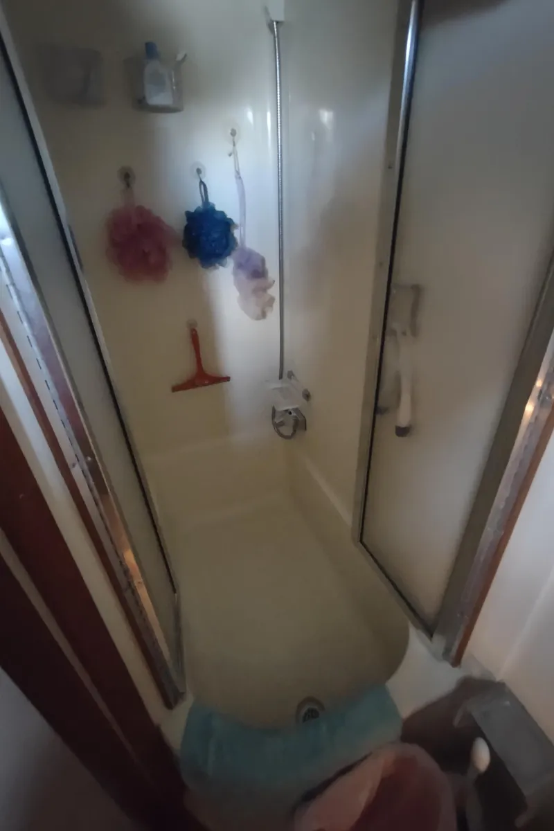Slide: The Image of Shower area inside 1987 Chris-Craft 381 Catalina boat, featuring hanging bath accessories. - 40