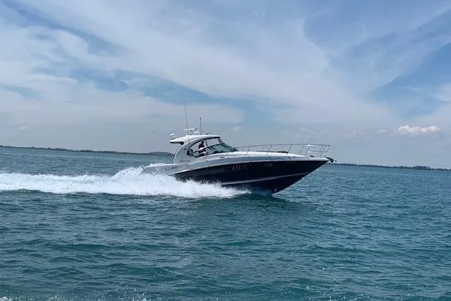 Slide: The Image of 2008 Sea Ray 400 Sundancer cruising on open water under a clear blue sky. - 26