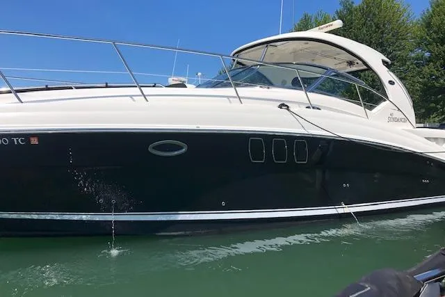 Slide: The Image of 2008 Sea Ray 400 Sundancer yacht on calm water, side view, under clear blue sky. - 27