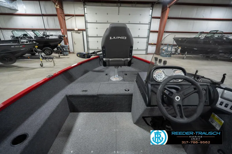 Slide: The Image of 2023 Lund 1650 Angler SS boat interior with steering wheel and dashboard in showroom. - 17