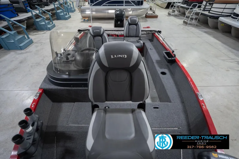 Slide: The Image of 2023 Lund 1650 Angler SS boat interior with seating and steering console in showroom. - 19