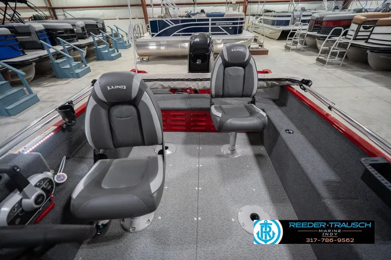 Slide: The Image of 2023 Lund 1650 Angler SS boat interior with two gray seats in a showroom. - 20