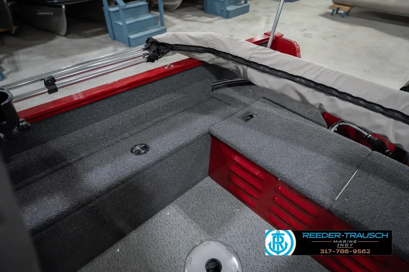 Slide: The Image of 2023 Lund 1650 Angler SS boat interior with gray carpet and red accents. - 22