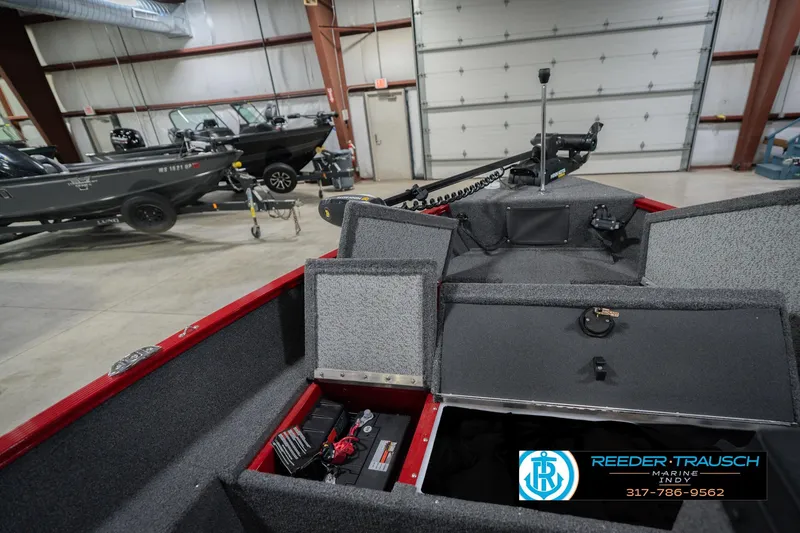 Slide: The Image of 2023 Lund 1650 Angler SS boat interior in showroom with storage compartments open. - 27