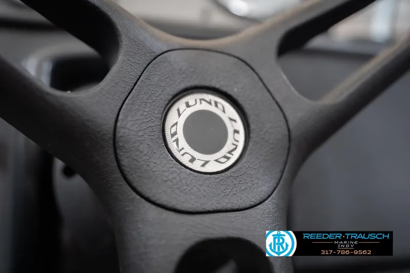 Slide: The Image of Steering wheel of 2023 Lund 1650 Angler SS boat, featuring logo detail. - 30