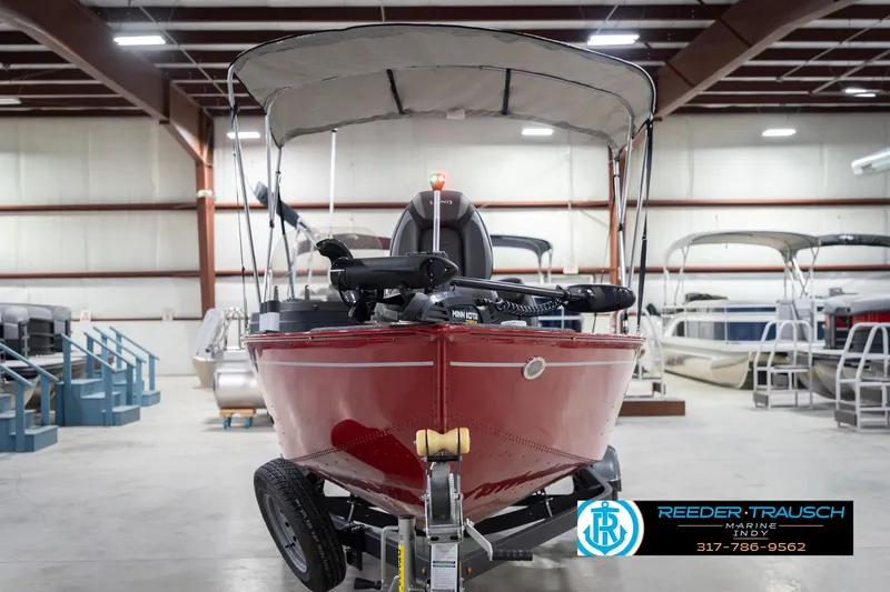 Slide: The Image of 2023 Lund 1650 Angler SS boat in showroom, red exterior, canopy, trailer attached. - 5