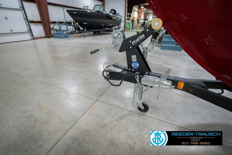 Slide: The Image of 2023 Lund 1650 Angler SS boat trailer in a showroom with contact details. - 51