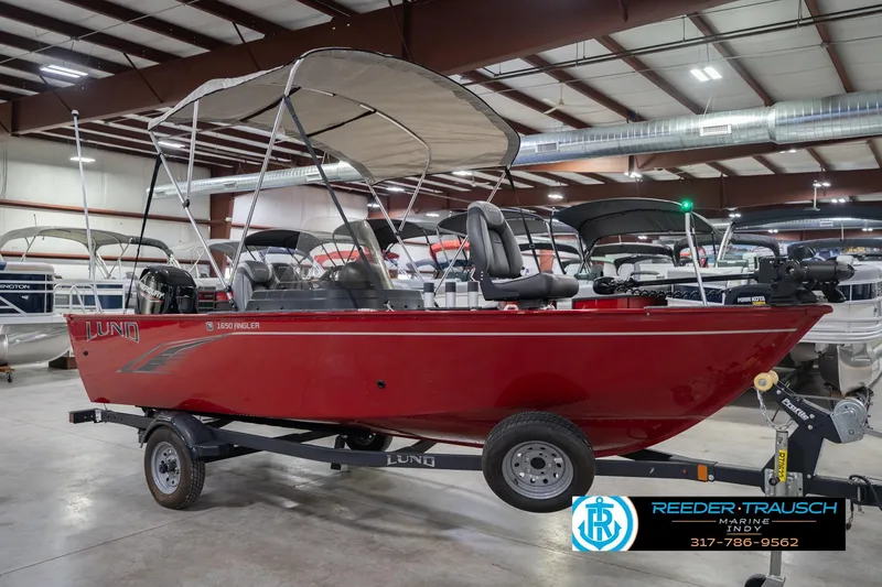 Slide: The Image of 2023 Lund 1650 Angler SS boat in showroom, red exterior, trailer included. - 6