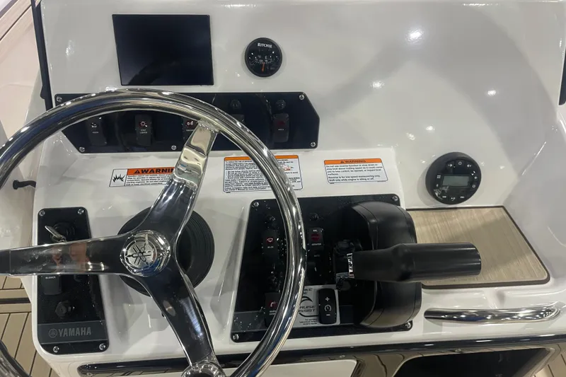 Slide: The Image of 2025 Yamaha Boats 195 FSH Sport dashboard with steering wheel and controls. - 11