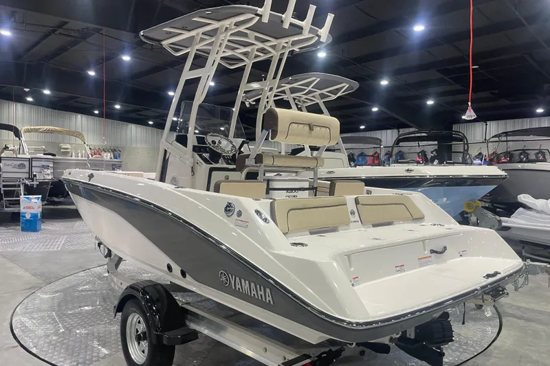 Slide: The Image of 2025 Yamaha Boats 195 FSH Sport displayed in a showroom, showcasing sleek design and features. - 2