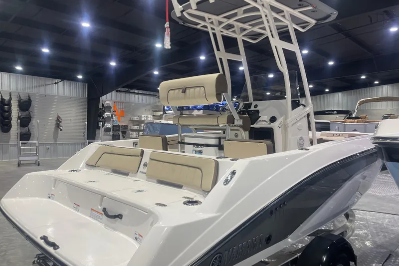 Slide: The Image of 2025 Yamaha Boats 195 FSH Sport in showroom, featuring sleek design and comfortable seating. - 3