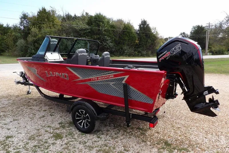 Slide: The Image of 2026 Lund 1775 Adventure Sport boat with Mercury Pro XS engine, parked on gravel. - 10