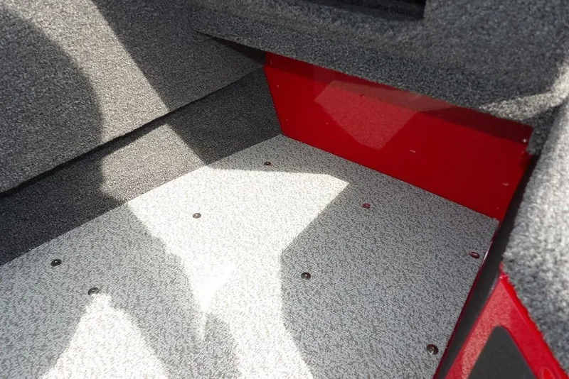 Slide: The Image of Interior of 2026 Lund 1775 Adventure Sport boat, featuring carpeted flooring and red accents. - 35