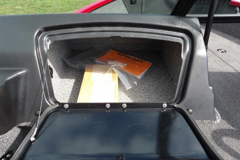 Slide: The Image of Open storage compartment in 2026 Lund 1775 Adventure Sport boat, showing documents inside. - 36