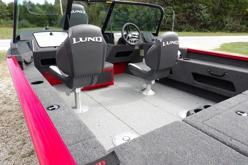 Slide: The Image of 2026 Lund 1775 Adventure Sport boat interior with gray carpet and black seats. - 4