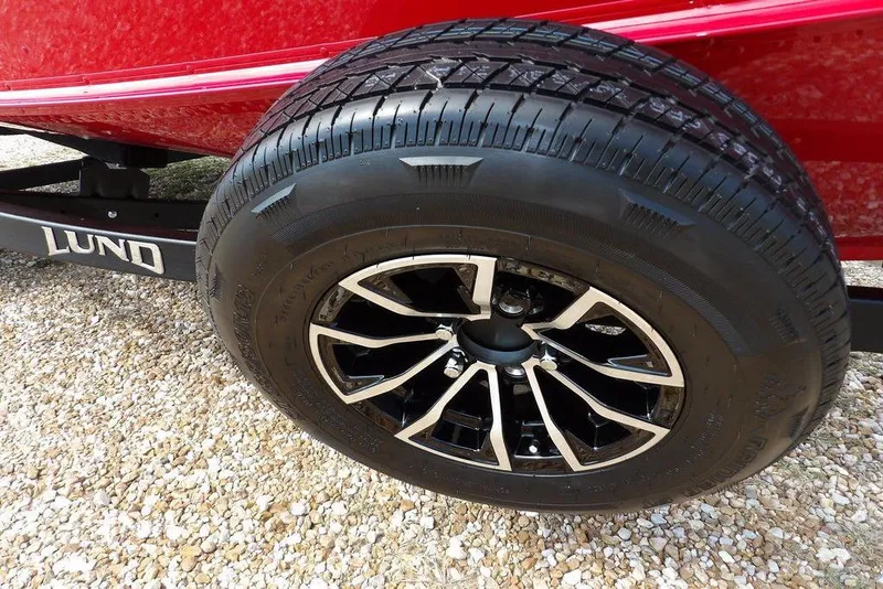 Slide: The Image of 2026 Lund 1775 Adventure Sport trailer wheel on gravel surface. - 47