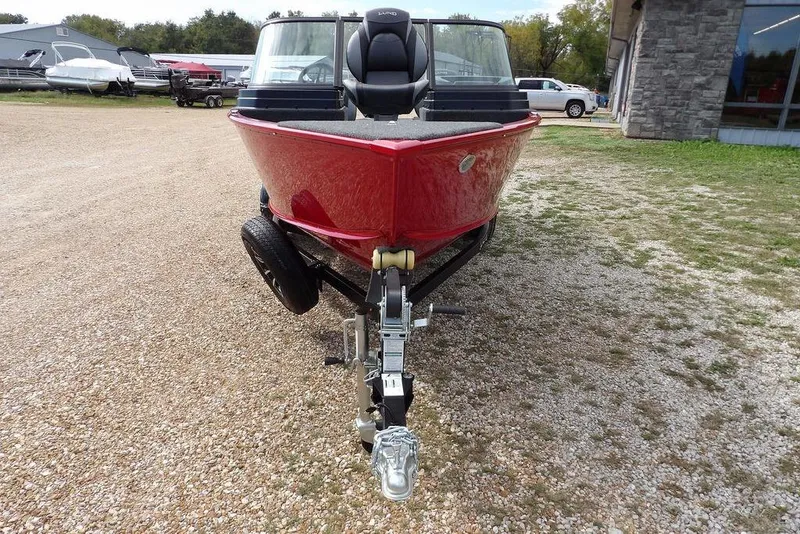 Slide: The Image of 2026 Lund 1775 Adventure Sport boat in red, parked on gravel near a building. - 5