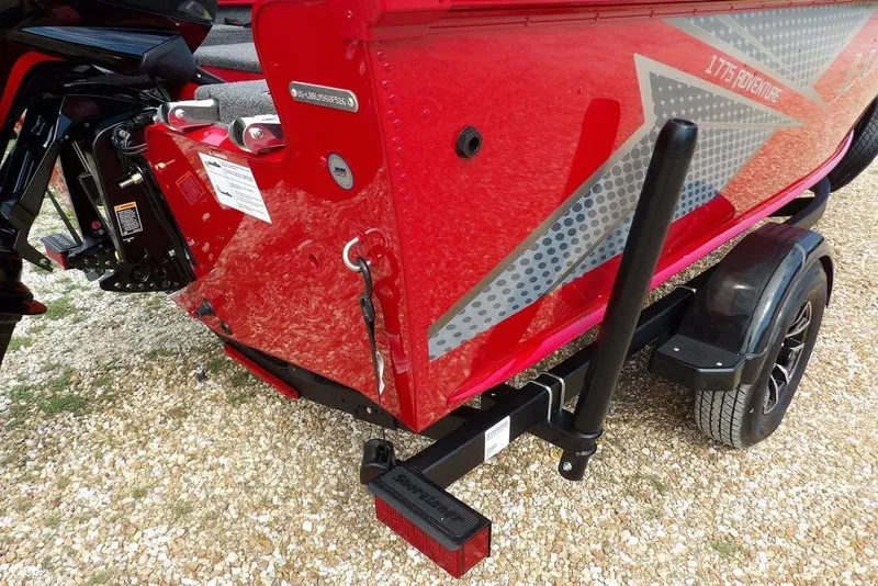 Slide: The Image of 2026 Lund 1775 Adventure Sport boat, red hull with graphic design, on a trailer. - 50