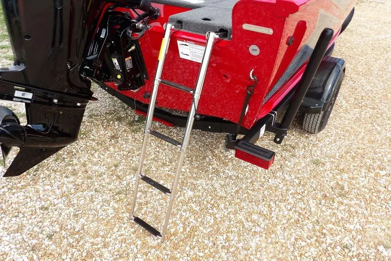 Slide: The Image of 2026 Lund 1775 Adventure Sport boat with ladder and motor, parked on gravel. - 57