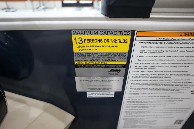 Slide: The Image of 2026 Godfrey Sweetwater 2286 C Tritoon capacity label, 13 persons or 1860 lbs, safety warnings. - 15