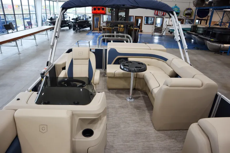 Slide: The Image of 2026 Godfrey Sweetwater 2286 C Tritoon interior with beige seating and steering console. - 7