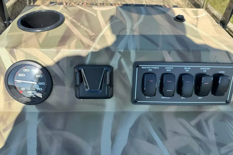 Slide: The Image of Control panel of 2026 Lowe Roughneck 2070CC boat with switches and RPM gauge. - 11