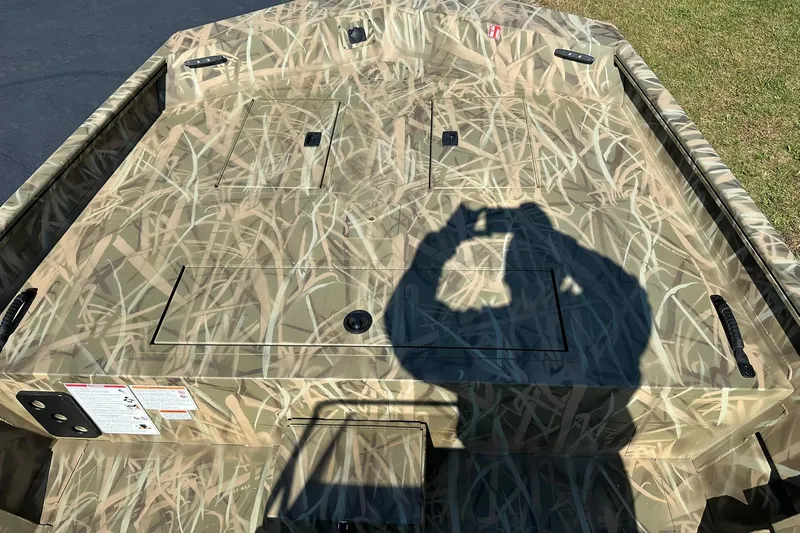 Slide: The Image of Camouflage-patterned deck of 2026 Lowe Roughneck 2070CC boat with shadow. - 13