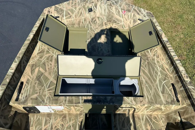 Slide: The Image of 2026 Lowe Roughneck 2070CC boat interior with open storage compartments and camouflage design. - 14