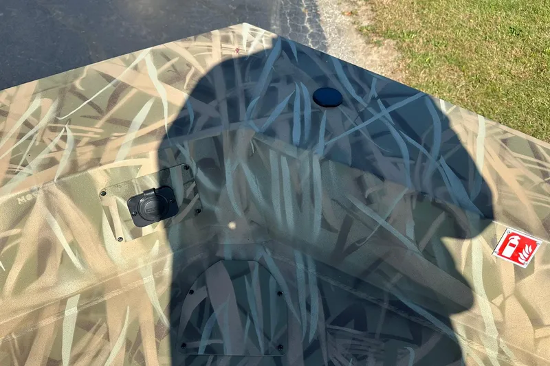 Slide: The Image of Camouflage pattern on Lowe Roughneck 2070CC boat, 2026 model, with shadow and fire extinguisher label. - 18