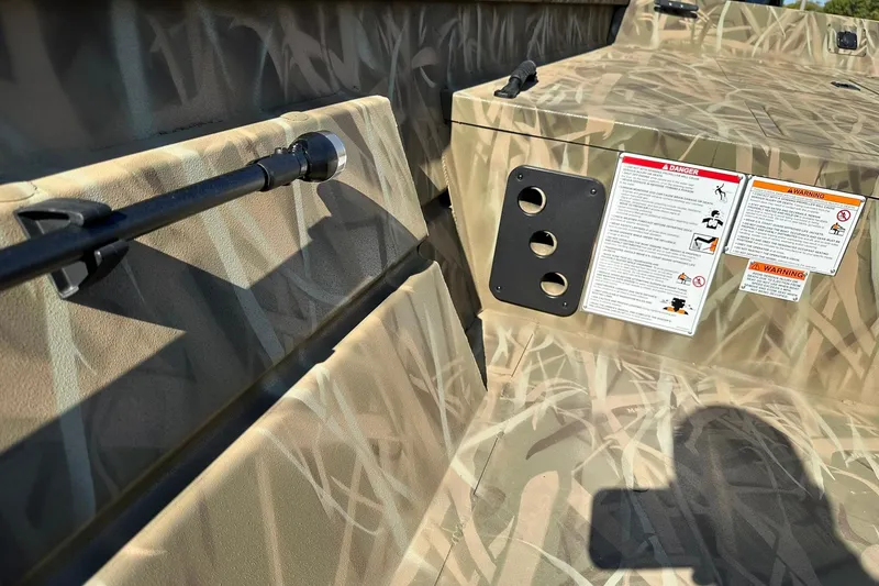Slide: The Image of Camouflage interior of 2026 Lowe Roughneck 2070CC boat with safety warnings and rod holder. - 19