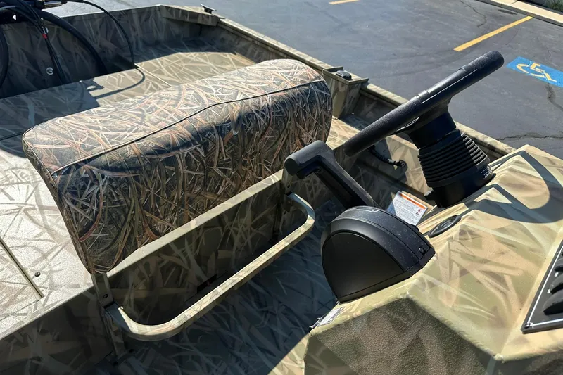 Slide: The Image of 2026 Lowe Roughneck 2070CC boat interior with camo seating and steering console. - 8