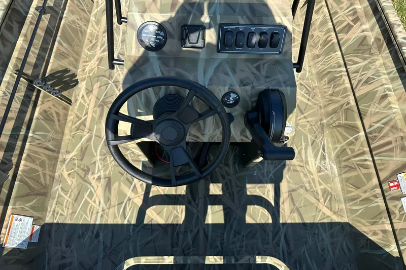 Slide: The Image of 2026 Lowe Roughneck 2070CC boat console with camouflage design and steering wheel. - 9
