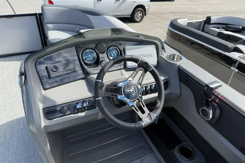 Slide: The Image of 2026 Tahoe Pontoon LTZ Versatile Rear Lounger dashboard with steering wheel and Garmin display. - 10