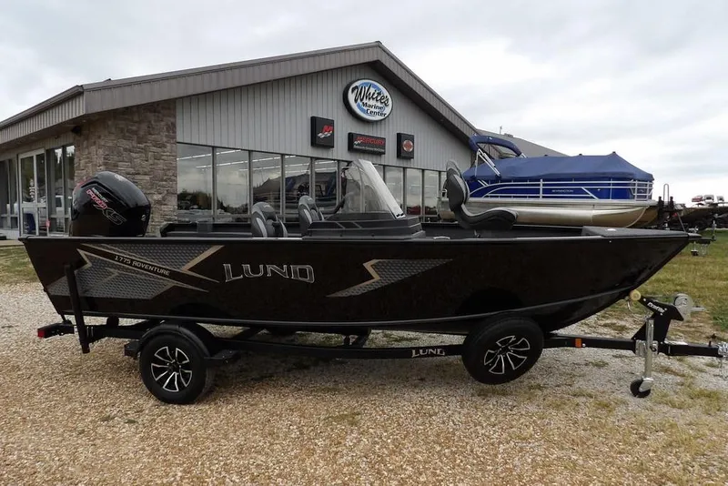 The Image of 2026 Lund 1775 Adventure SS boat on trailer outside dealership. - 1