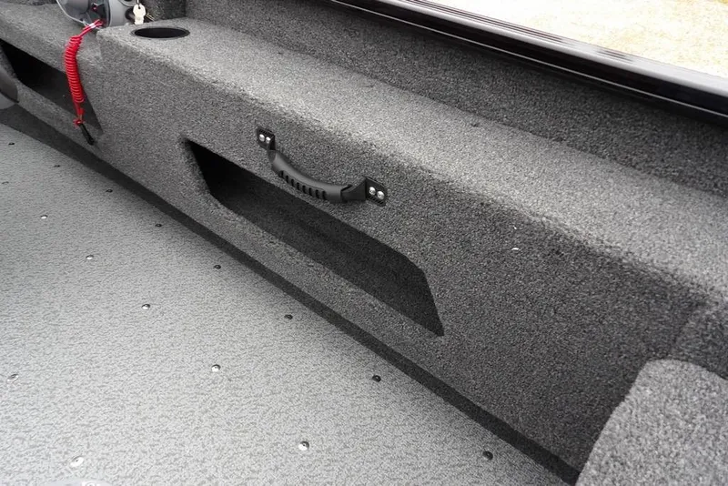 Slide: The Image of 2026 Lund 1775 Adventure SS boat interior with gray carpet and storage compartment. - 17