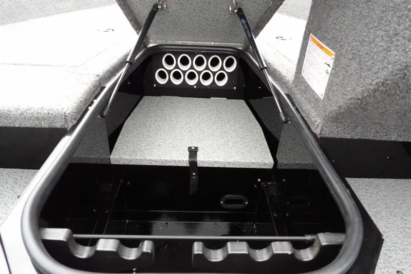 Slide: The Image of 2026 Lund 1775 Adventure SS boat storage compartment with rod holders and carpeted interior. - 28