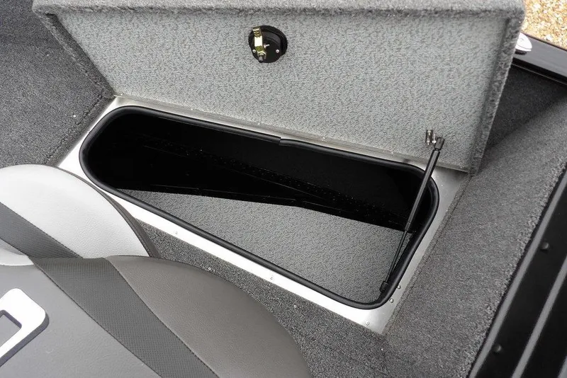 Slide: The Image of 2026 Lund 1775 Adventure SS boat storage compartment with open lid and gray interior. - 34