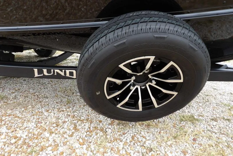 Slide: The Image of 2026 Lund 1775 Adventure SS trailer wheel on gravel surface. - 35