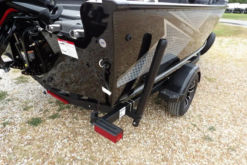 Slide: The Image of 2026 Lund 1775 Adventure SS boat on trailer, rear view, parked on gravel. - 36