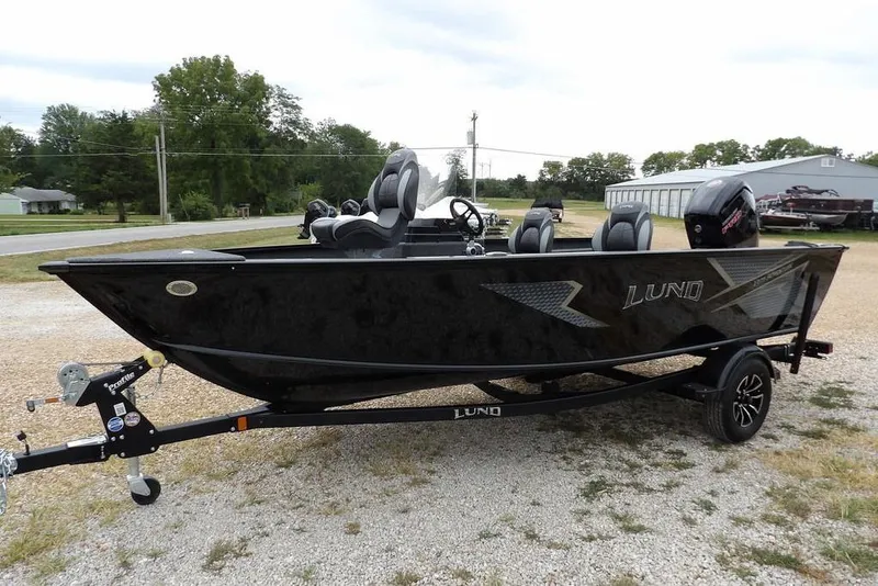 Slide: The Image of 2026 Lund 1775 Adventure SS boat on trailer, black exterior, parked outdoors. - 7