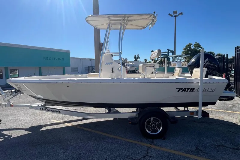 The Image of Pathfinder 2005 TRS boat on trailer, parked outdoors under clear blue sky. - 0