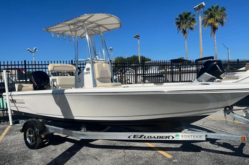 Slide: The Image of Pathfinder 2005 TRS boat on EZ Loader trailer, 2022 model, parked outdoors. - 2