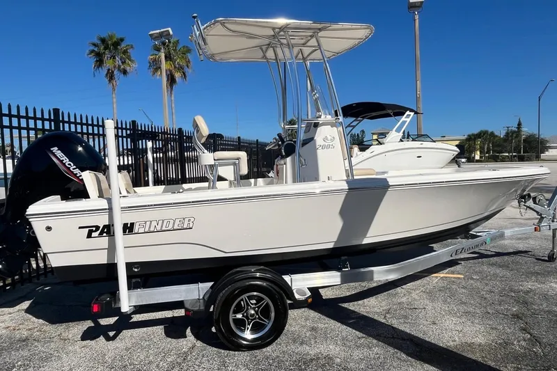 Slide: The Image of Pathfinder 2005 TRS boat on trailer, 2022 model, parked outdoors under clear blue sky. - 3