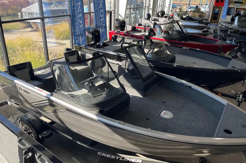 The Image of 2026 Crestliner 1650 Hawk boat displayed in a showroom with other models. - 0